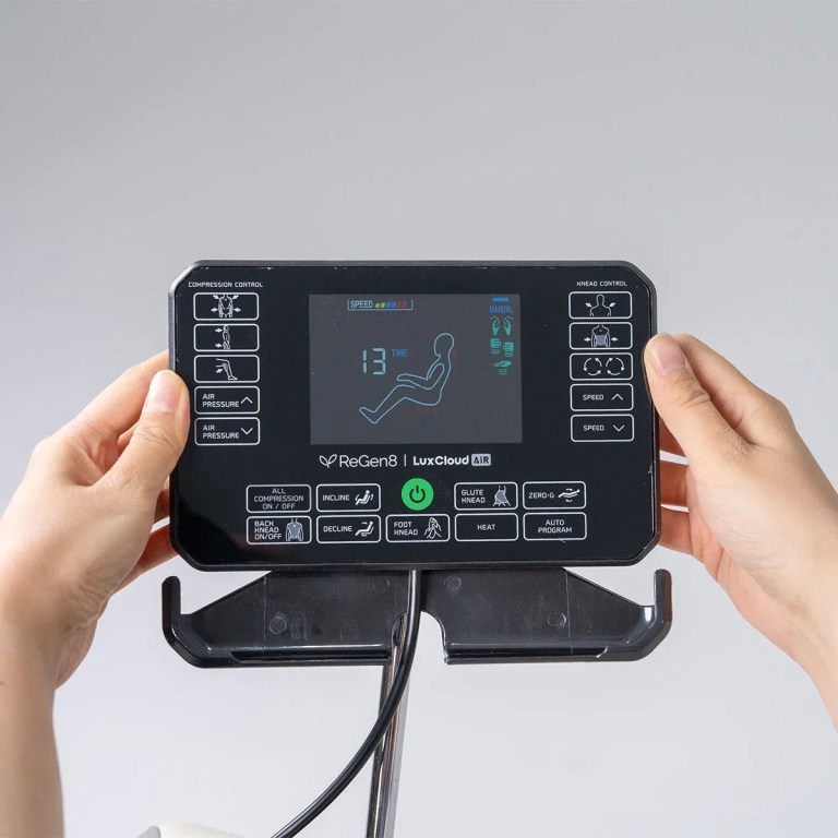Hands holding massage chair remote control panel