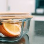Glass container with orange slices and wooden lid