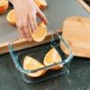 Squeezing lemon over salmon fillets in glass dish