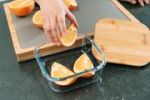 Squeezing lemon over salmon fillets in glass dish