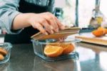Slicing fresh oranges on kitchen bench