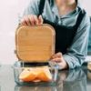Person sealing glass container with bamboo lid