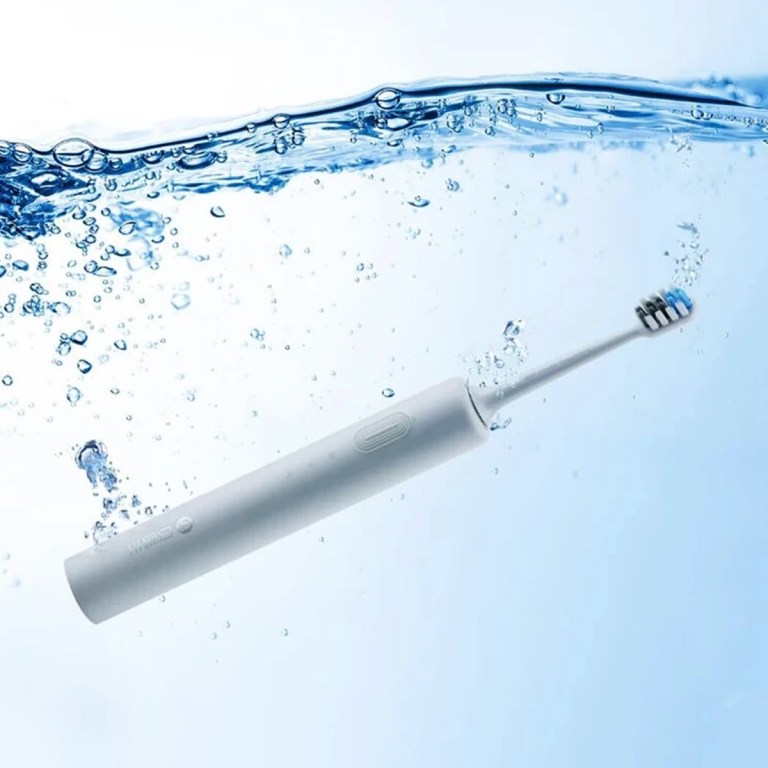 Electric toothbrush submerged in water with bubbles