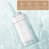 Portable water flosser on light blue surface