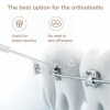 Water flosser cleaning braces on teeth model