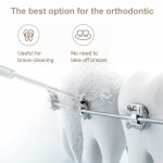 Water flosser cleaning braces on teeth model