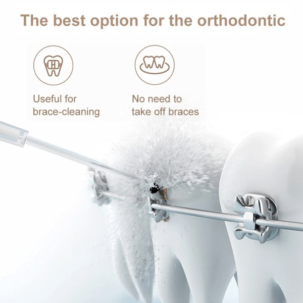 Water flosser cleaning braces on teeth model