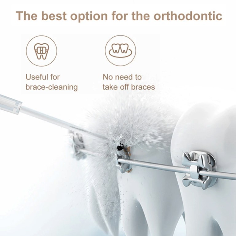 Water flosser cleaning braces on teeth model