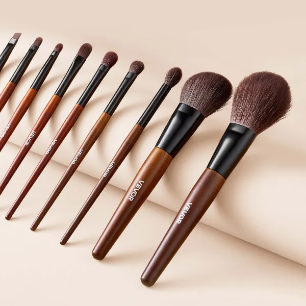 Set of wooden-handled makeup brushes on beige background