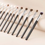 Set of professional makeup brushes on beige background