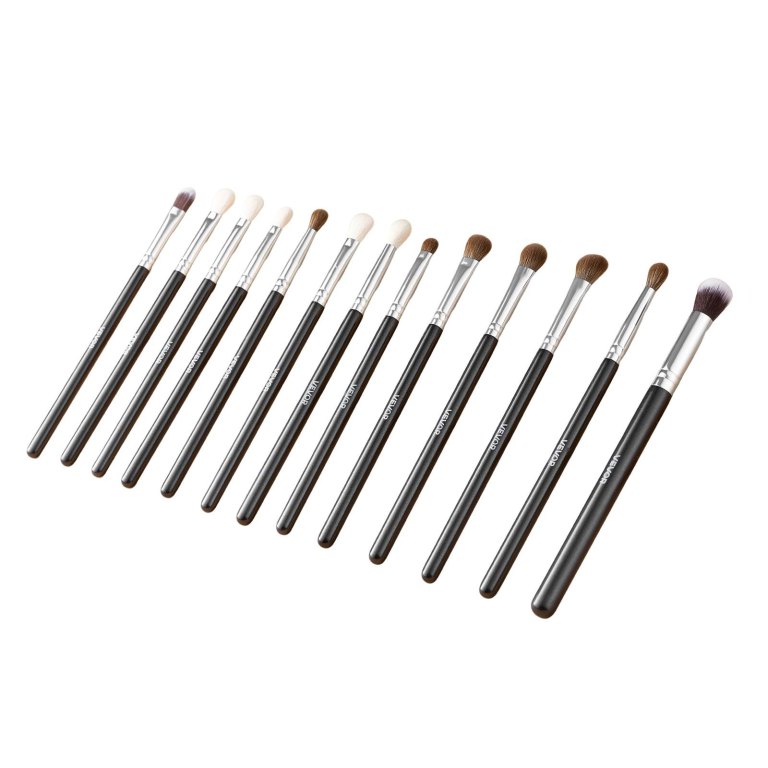 Set of assorted makeup brushes on white background