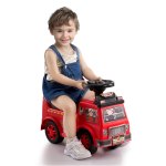 Smiling child riding red toy fire truck