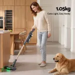 Woman using lightweight cordless vacuum in modern kitchen