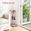 Folded pink exercise machine stored beside sofa