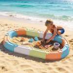 Young boy playing in beach sandbox by ocean