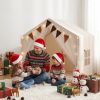 Family exchanging Christmas gifts in decorated indoor tent