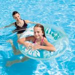 Woman and girl enjoying pool with inflatable ring