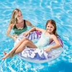 Mother and daughter enjoying pool with inflatable ring