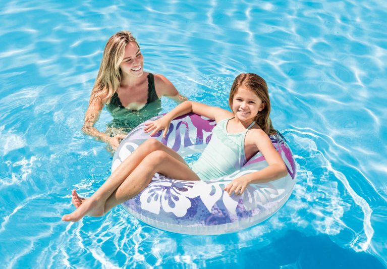 Mother and daughter enjoying pool with inflatable ring