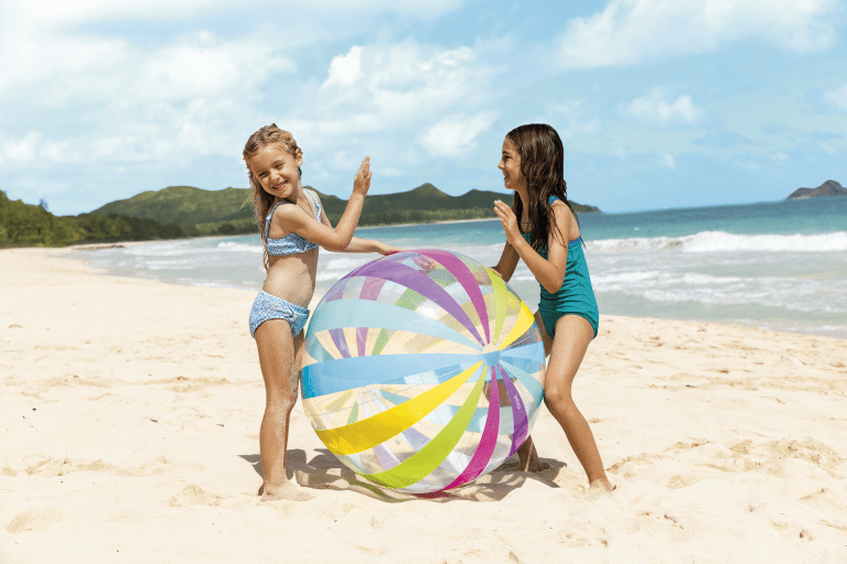 Two girls playing with colourful beach ball