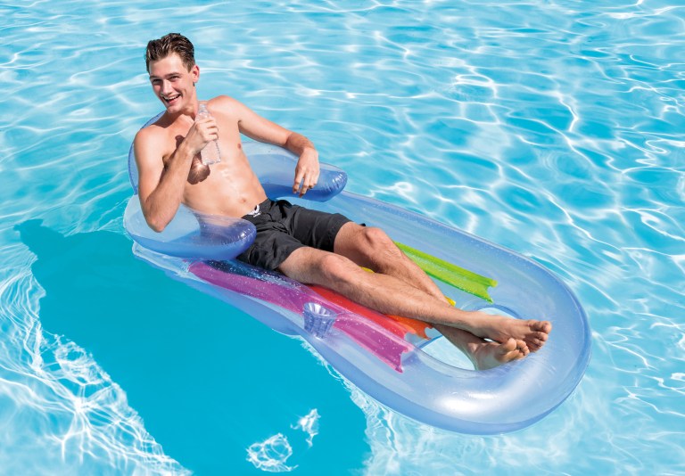 Man relaxing on inflatable pool float with water bottle