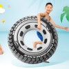 Boy holding tyre-shaped pool float beside smiling woman