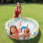 Woman and children splashing in backyard inflatable pool
