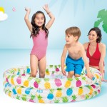 Family playing in inflatable pool with beach backdrop