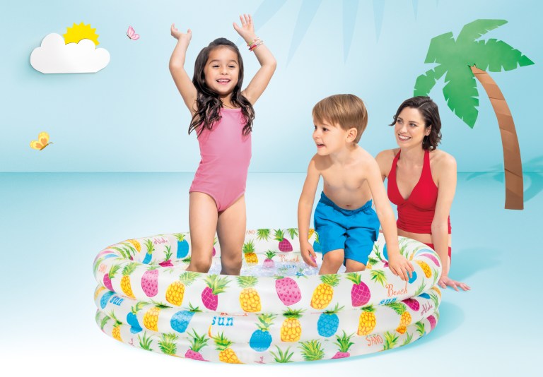 Family playing in inflatable pool with beach backdrop