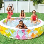 Family splashing in inflatable pool in backyard