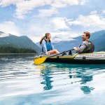 Couple kayaking on calm mountain lake