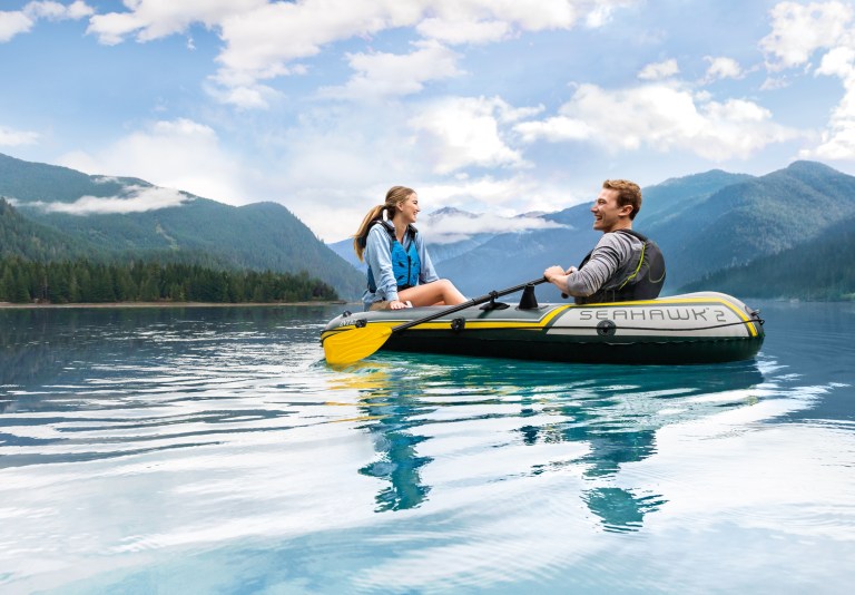Couple kayaking on calm mountain lake