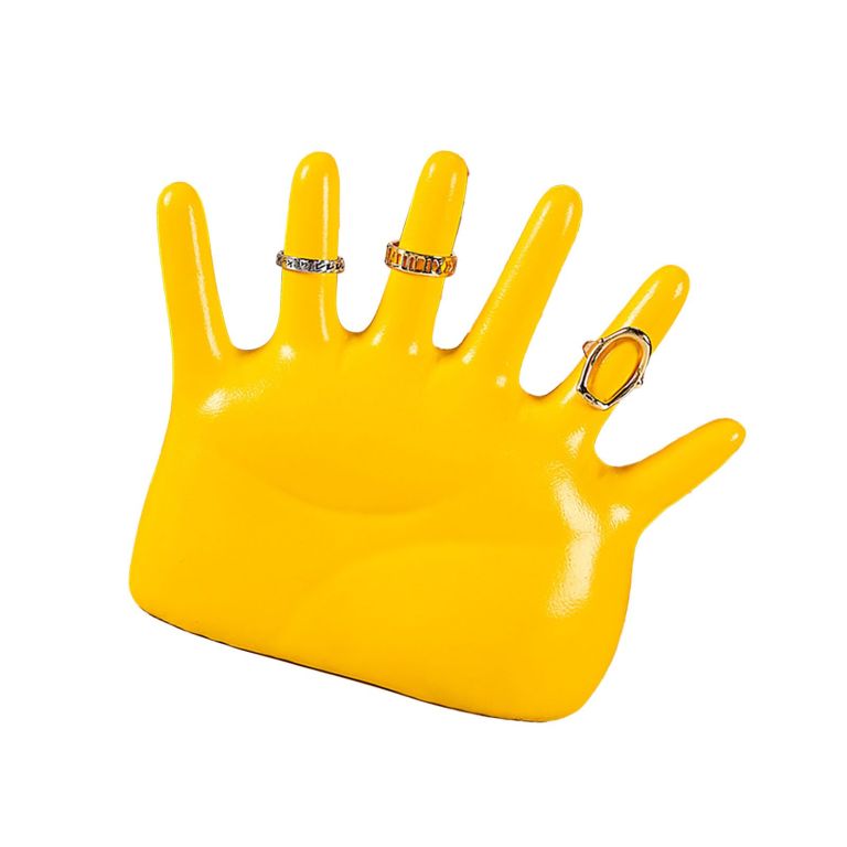 Yellow mannequin hand displaying decorative rings