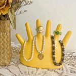 Yellow hand jewellery holder with rings and necklaces