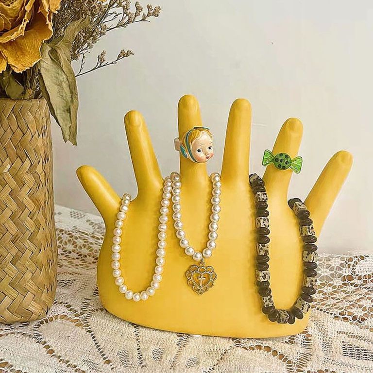 Yellow hand jewellery holder with rings and necklaces