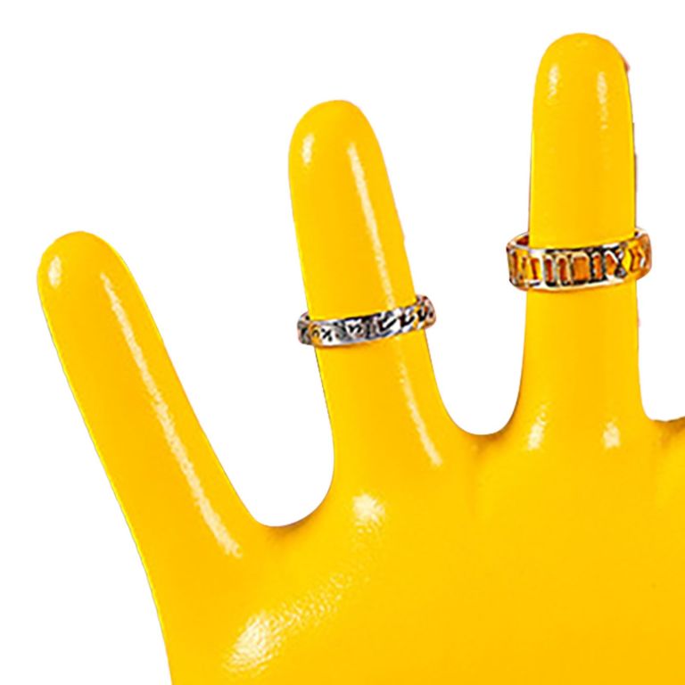Silver rings on yellow hand display stand