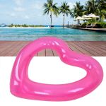 heart pool float pvc material skin friendly lightweight pink romantic style floating tubes for summer Pink heart-shaped pool float at tropical resort
