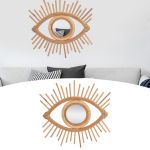 Eye-shaped rattan wall mirror above grey sofa