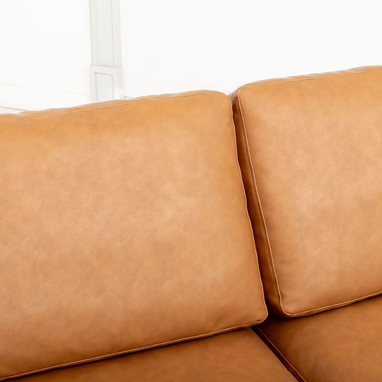 modern deep seated sofa, two seater, faux leather, brown brown pu leather Close-up of tan leather sofa cushions