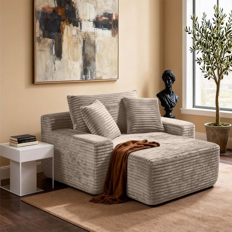 Modern beige armchair with ottoman in stylish lounge