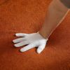 White gloved hand on orange textured carpet