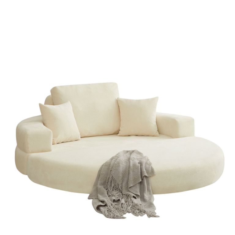 Cream curved sofa with cushions and throw