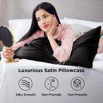 Woman relaxing on black satin pillowcase holding mirror