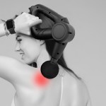 Woman using massage gun on sore shoulder