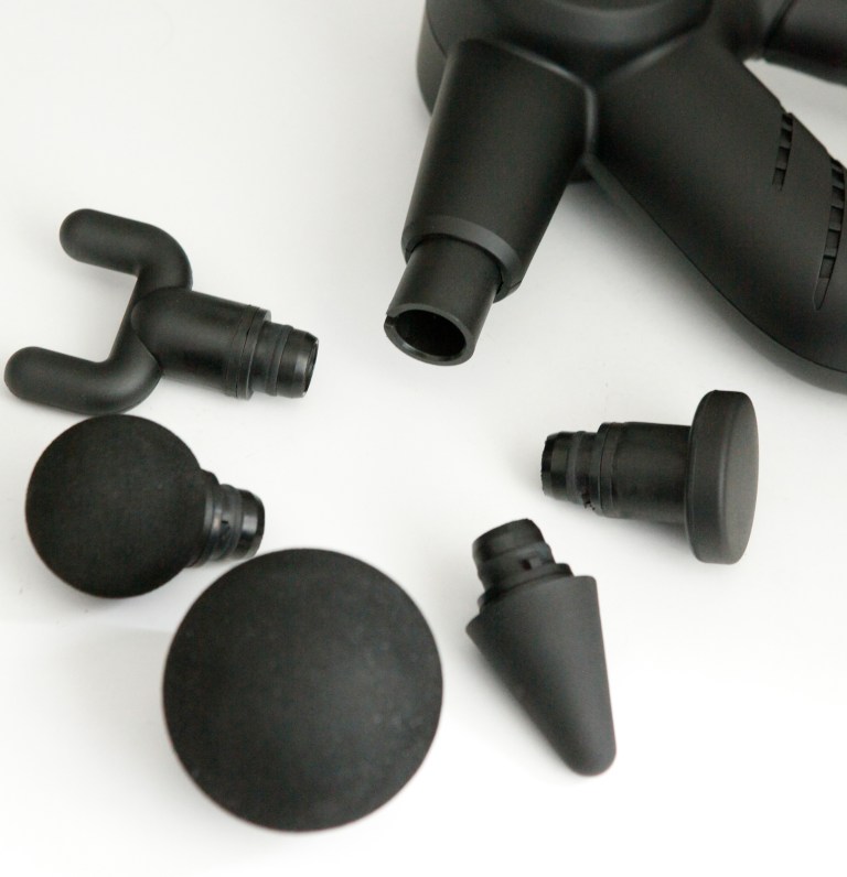 Black massage gun with interchangeable attachment heads