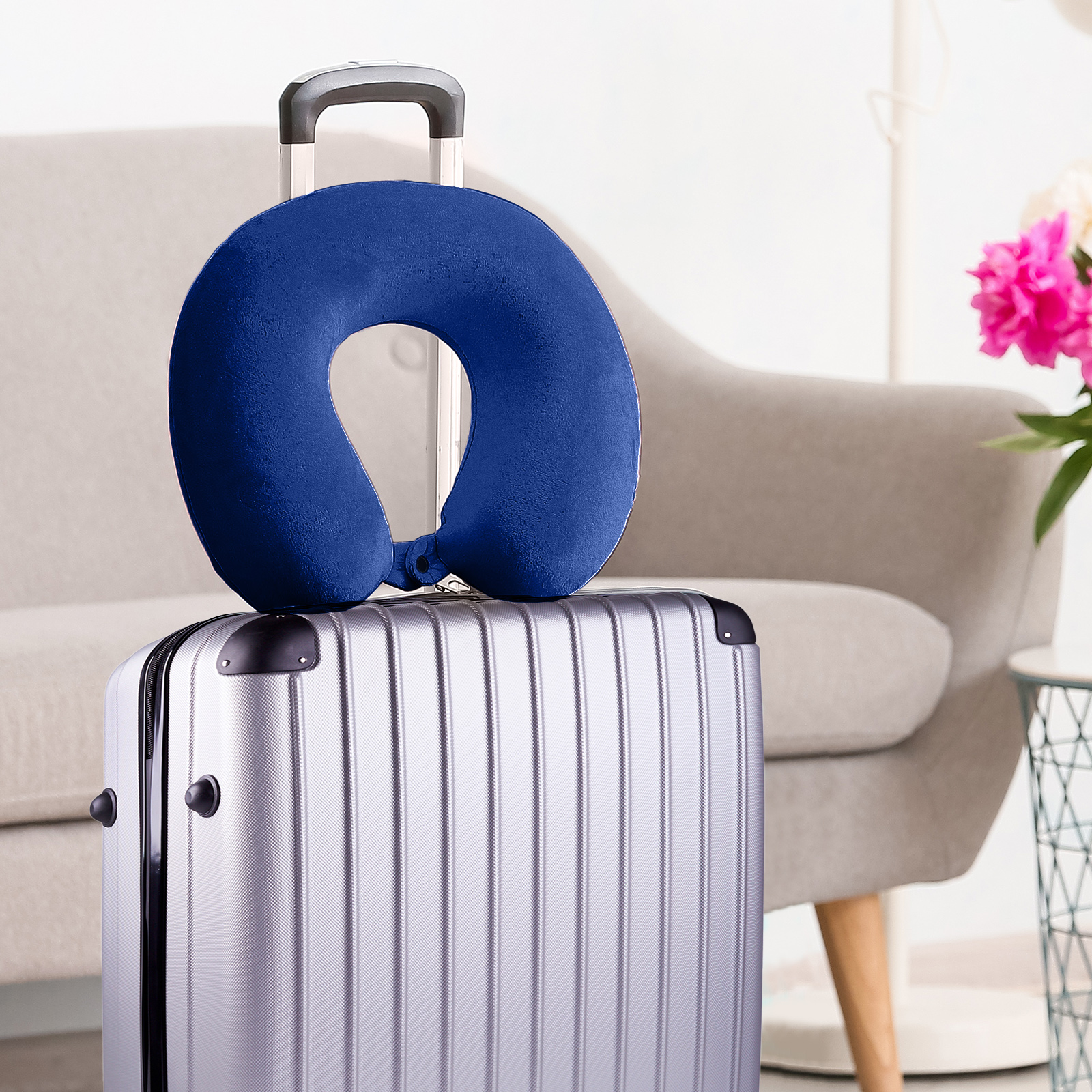 Blue travel neck pillow on silver suitcase