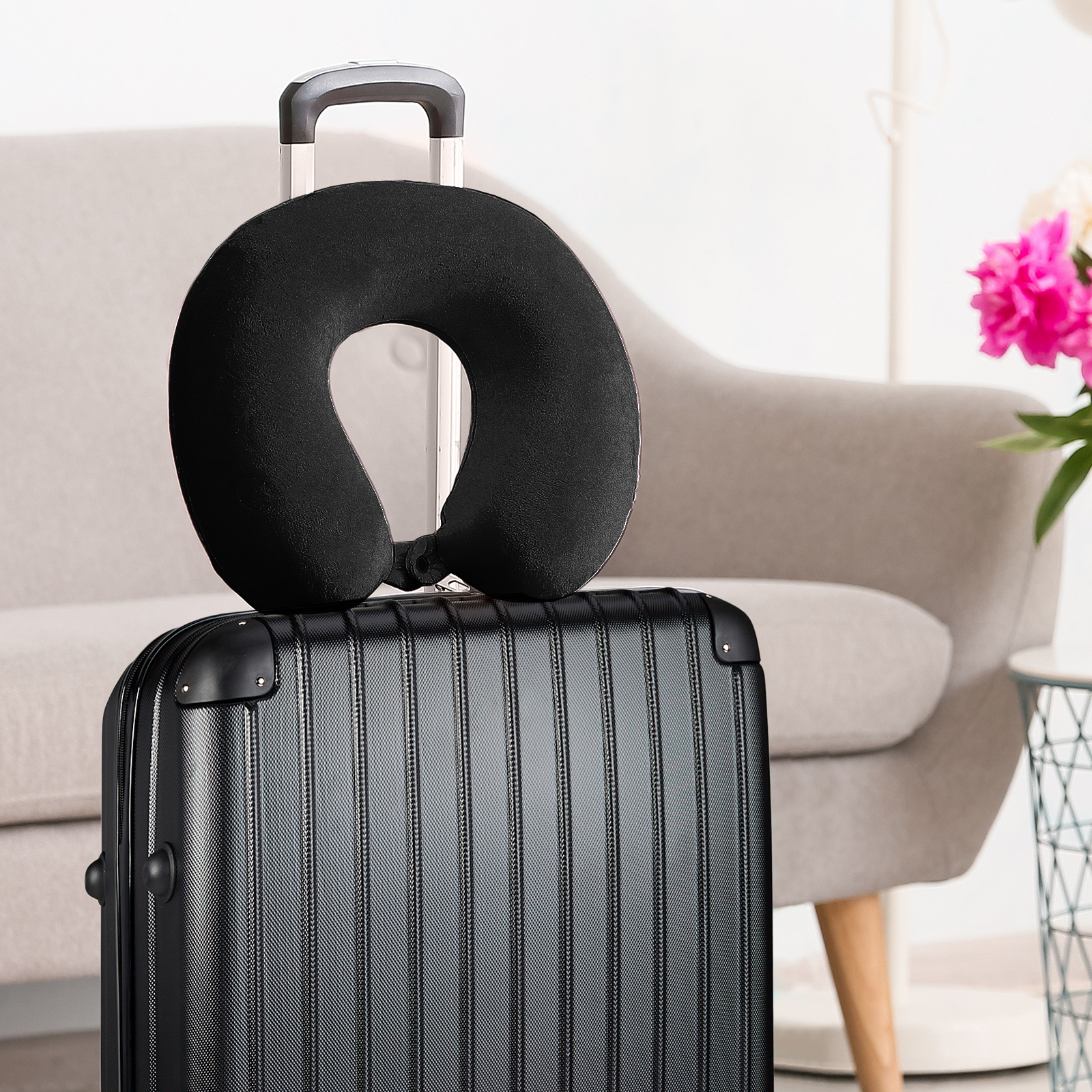 Black travel neck pillow on suitcase handle