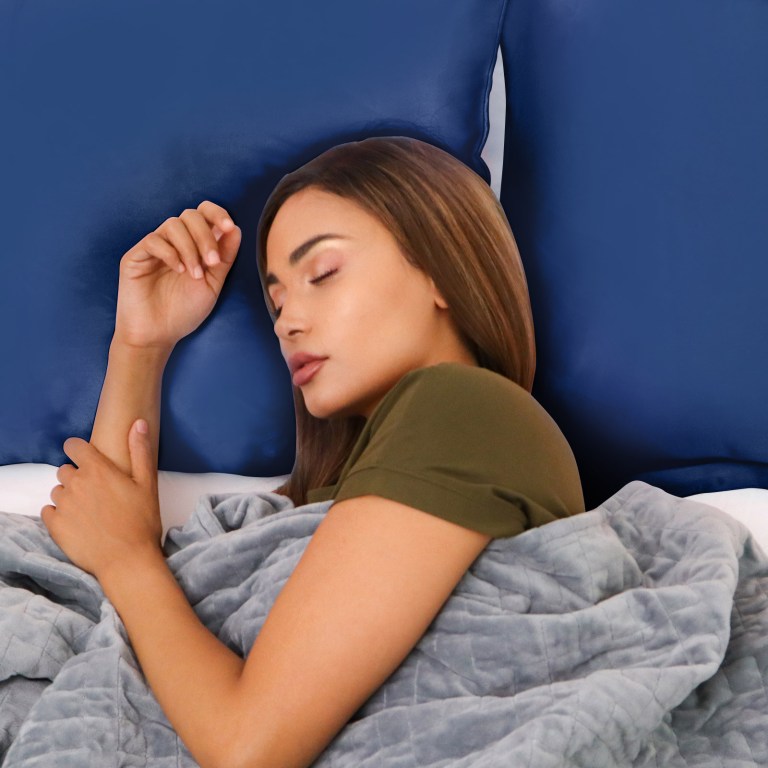 Woman sleeping peacefully on blue pillow in bed