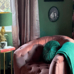 Cosy pink armchair with green decor by window