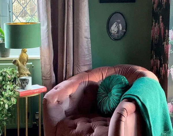 Cosy pink armchair with green decor by window